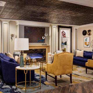 A luxurious and modern living room featuring blue sofas, elegant armchairs, and a sophisticated decor.