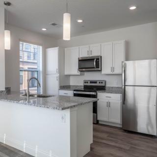 A modern kitchen featuring stainless steel appliances and white cabinetry.