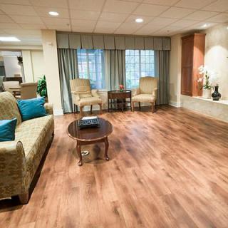 A cozy living room with hardwood floors, featuring a sofa, chairs, and a coffee table.