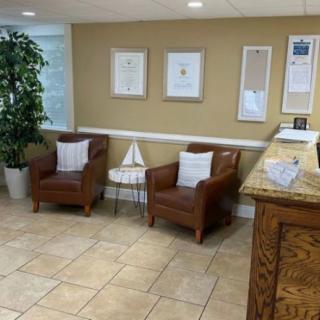 Cozy waiting area with chairs and framed certificates on the wall.