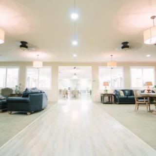 A spacious and modern living room with ample seating and lighting.