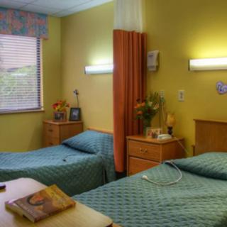 A shared hospital room with two patient beds and a curtain divider.