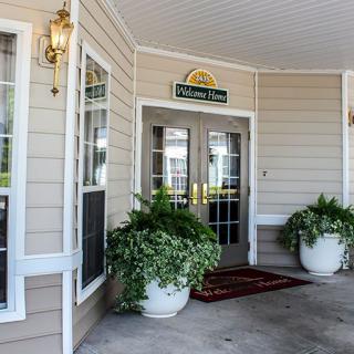 Entrance of a building with decorative plants and double doors.