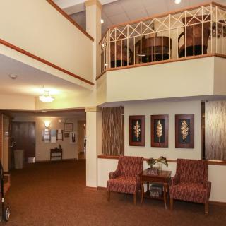 A spacious lobby with comfortable seating, artwork on the walls, and a decorative staircase.