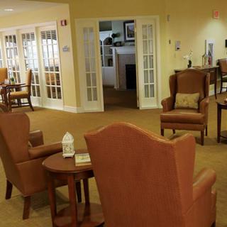 A cozy living room with comfortable chairs and small tables arranged in a seating area.
