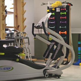 A variety of exercise equipment in a gym setting, including machines and free weights.