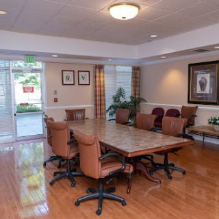 A modern conference room equipped with a large wooden table and comfortable chairs, ideal for meetings.