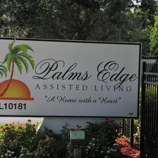 Sign for Palms Edge Assisted Living facility with palm tree imagery.