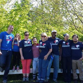A group of people posing together outdoors on a sunny day.