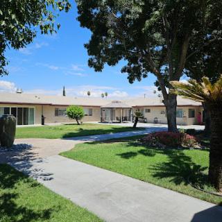 A serene residential area showcasing a well-maintained landscape with trees and a clear sky.