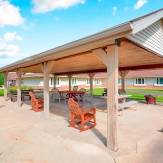 A covered outdoor patio area with seating and furniture under a clear blue sky.