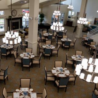An elegant dining area with neatly arranged tables and chandeliers.