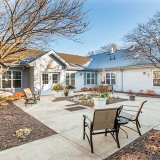 A peaceful residential courtyard with patio chairs and landscaping.