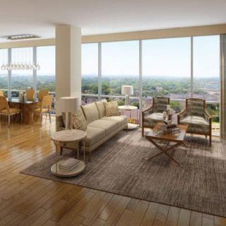 A modern living room with large windows offering a stunning city view, featuring elegant furniture and abundant natural light.