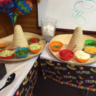 A vibrant taco bar setup featuring cone-shaped tortilla shells and a variety of fresh toppings.