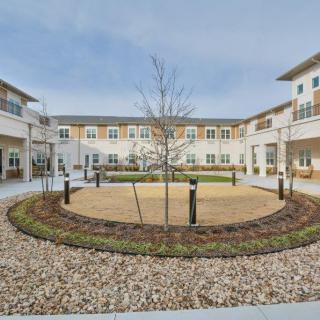 A modern building courtyard with a central landscaped area and surrounding pathways.