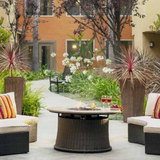 A cozy outdoor patio area with comfortable seating and lush landscaping.