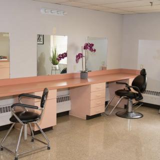 An empty salon with chairs and mirrors, decorated with flowers.
