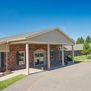 A welcoming residential building with a well-maintained entrance and lush green surroundings.