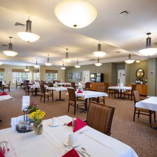 A spacious and well-lit dining area with tables set for service.