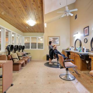 A cozy salon interior with a hairdresser attending to a client.