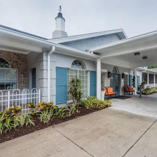 An exterior view of a building with a covered entrance and landscaping.