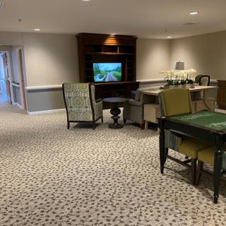 A cozy lounge area with a television, comfortable chairs, and a card table.