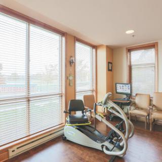A bright and modern home gym featuring exercise equipment and comfortable seating.
