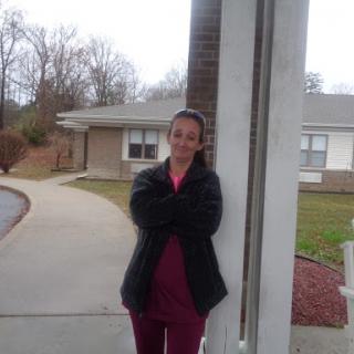 A person standing outside a building with a smile.