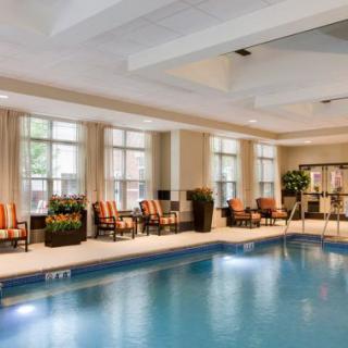A luxurious indoor swimming pool with seating area and large windows.