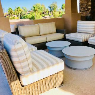 Outdoor patio seating area with sofas, chairs, and tables.