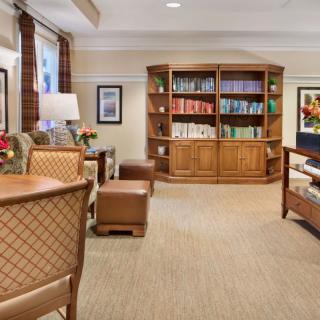 A cozy living room with a wooden bookshelf and comfortable seating.