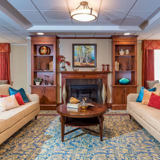 A cozy living room with two sofas, a fireplace, and decorated shelves.