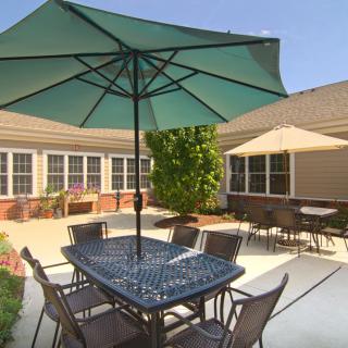 A sunny patio with outdoor seating featuring tables and umbrellas.