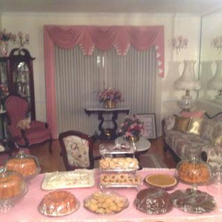 A traditional living room setup with a variety of desserts displayed on a table, surrounded by classic furnishings and decor.