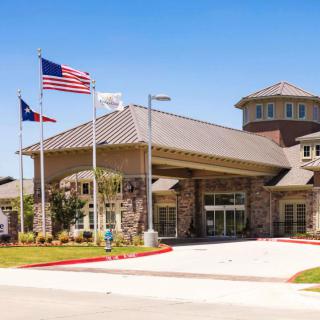 A modern building with a prominent entrance and American flags displayed outside.