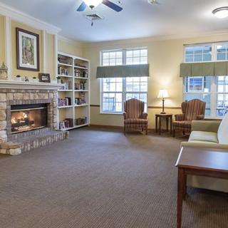 A cozy living room with a fireplace, bookshelves, and comfortable seating.