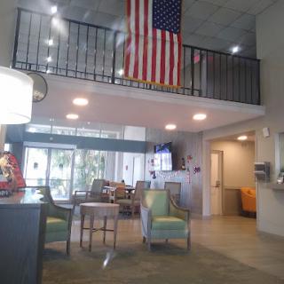 A welcoming lobby featuring modern seating arrangements and an American flag prominently displayed.