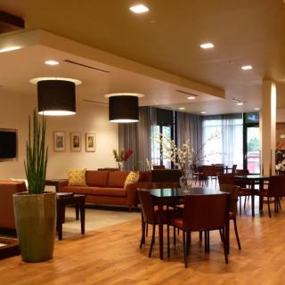 A modern living room and dining area with warm lighting and stylish furnishings.