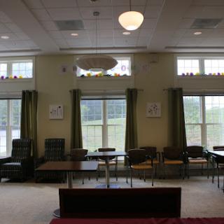 A cozy lounge area featuring comfortable seating, large windows, and a welcoming atmosphere.