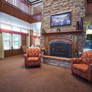 A cozy living room with a stone fireplace and comfortable chairs.
