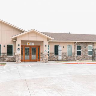 Exterior view of a building with a prominent entrance and stone facade.