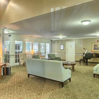 A cozy lounge area featuring sofas, a piano, and warm lighting.