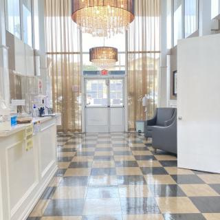 A modern lobby featuring elegant chandeliers and a checkered floor design.