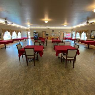 A spacious dining area set up with red tablecloths, perfect for events or gatherings.