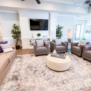 A modern living room with comfortable seating, a large rug, and decorative elements.