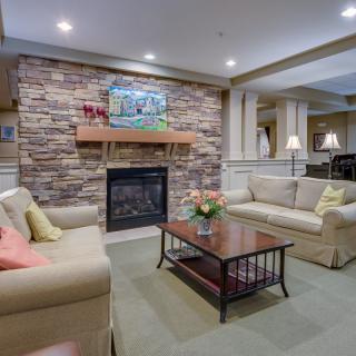 A cozy living room with a stone fireplace and comfortable seating.