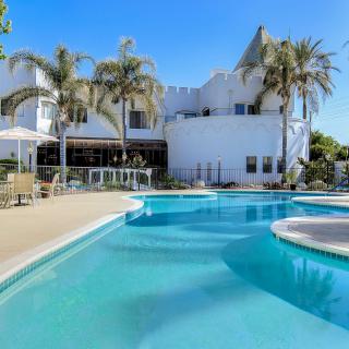 A luxurious house with a stunning outdoor swimming pool and palm trees.