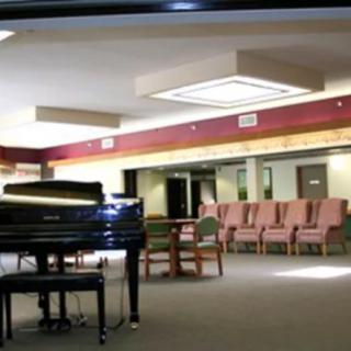 A spacious lobby featuring a grand piano and comfortable seating arrangements.