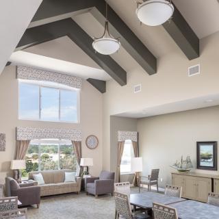 A spacious, modern living room with high ceilings and large windows.